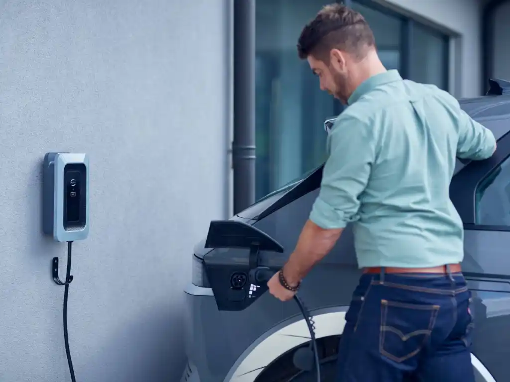 Man plugging a charging cable into an electric vehicle - residential EV charger installation
