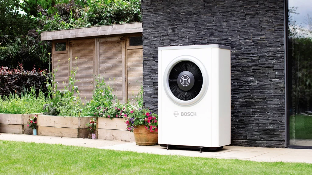 A white Bosch air source heat pump installed in a garden – air source heat pump service and maintenance 